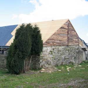 maçon travaille sur mur du gîte